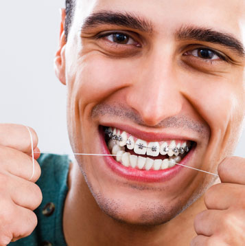 Adult Braces Provo, UT - man flossing with braces smiling